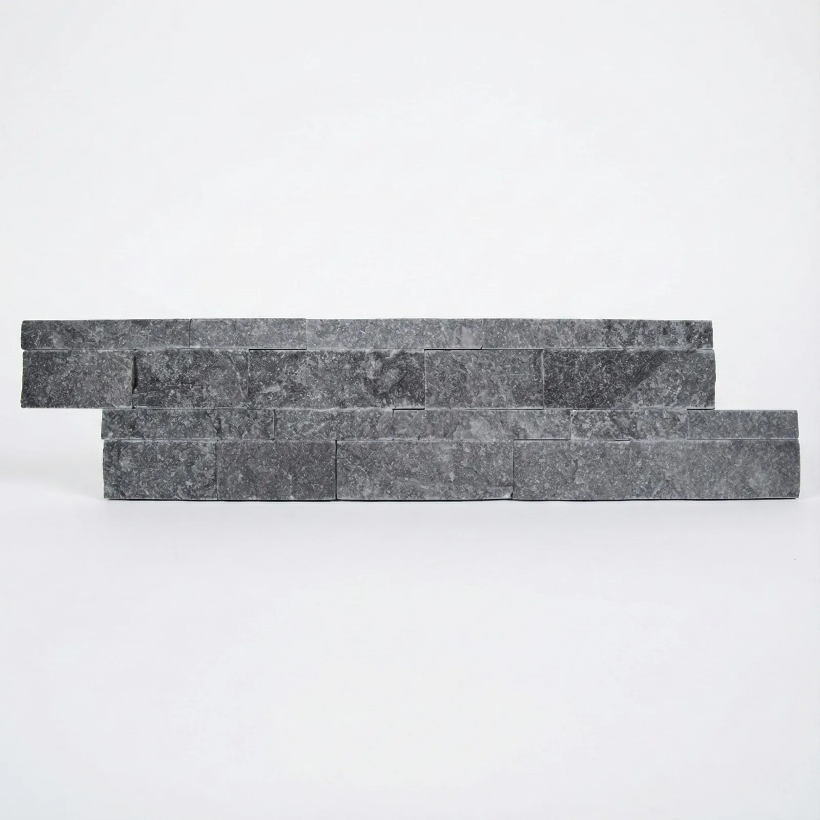 Two courses of black marble ledger panel on a pale studio ground, the near-black split faces edged with lighter grey.