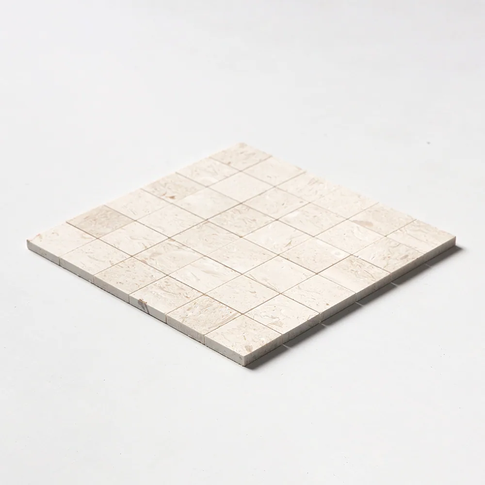 Desert Path limestone mosaic of two-inch squares in soft sand-beige, brushed to a matt finish, the sheet seen at a shallow angle.