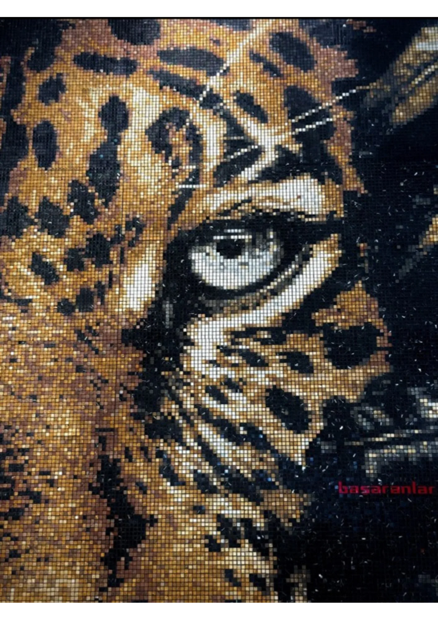 Close photograph of the finished mosaic: the leopard's eye and cheek in real stone and glass, individual tesserae throwing scattered specular glints at different angles, the physical relief of each piece visible at the grout lines.